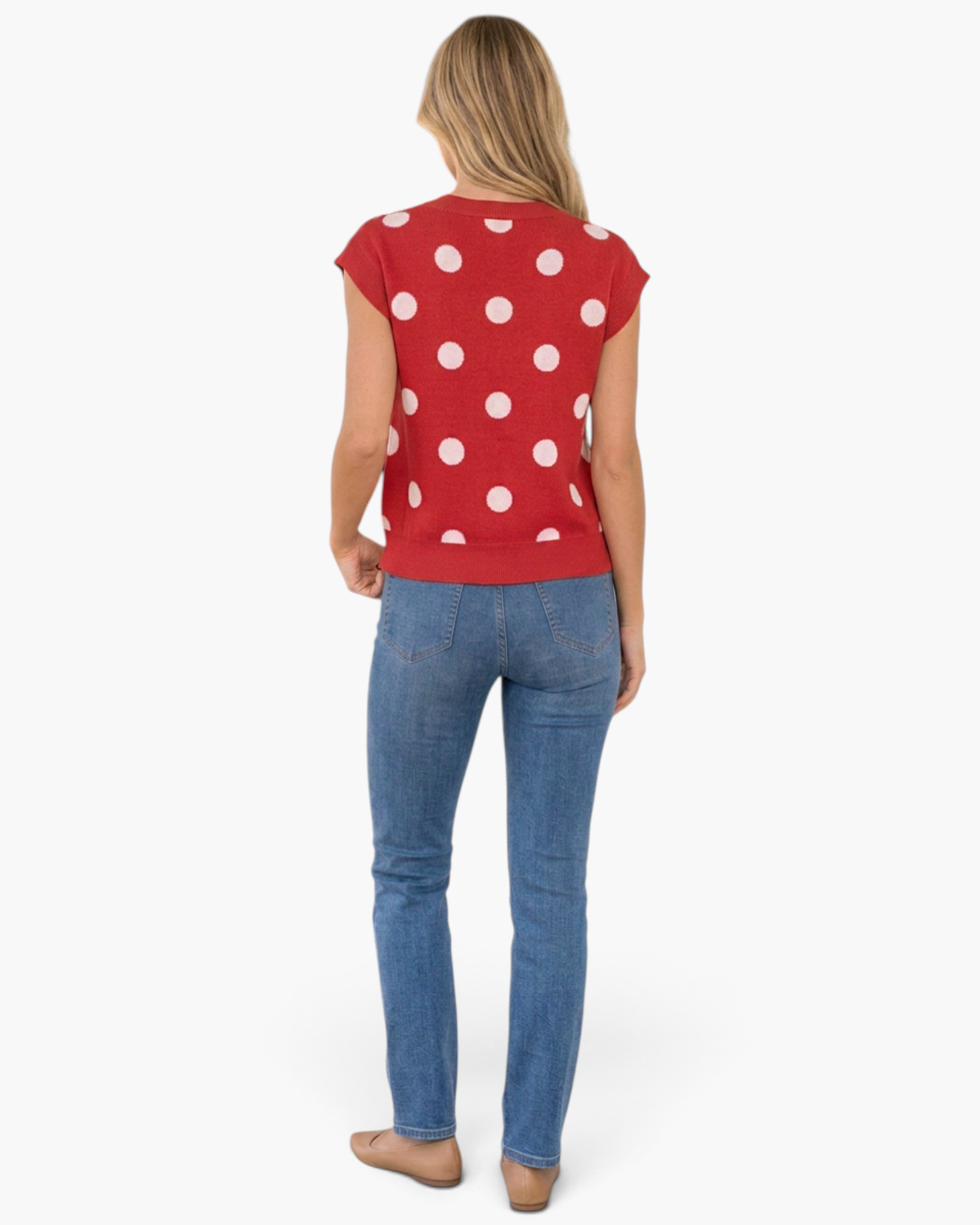 Beach Rose Co. red sleeveless sweater vest with white polka dots, worn with blue jeans, back view.