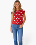 Beach Rose Co. red sleeveless sweater vest with white polka dots and gold button front worn by a smiling model.