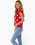 Beach Rose Co. red sleeveless sweater vest with white polka dots, round neck, and gold buttons, worn by a model.