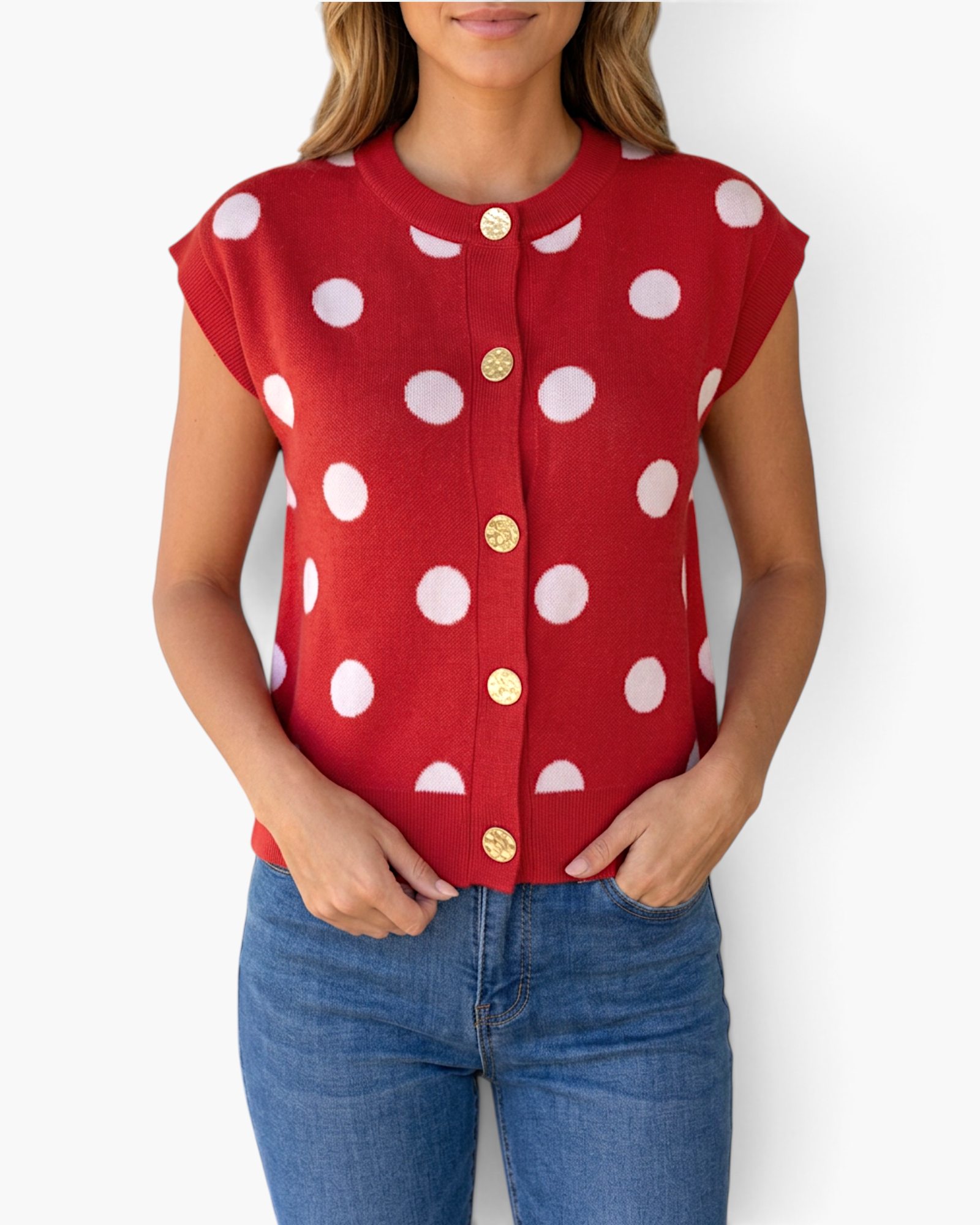Beach Rose Co. red sleeveless sweater vest with white polka dots and gold decorative buttons worn with blue jeans