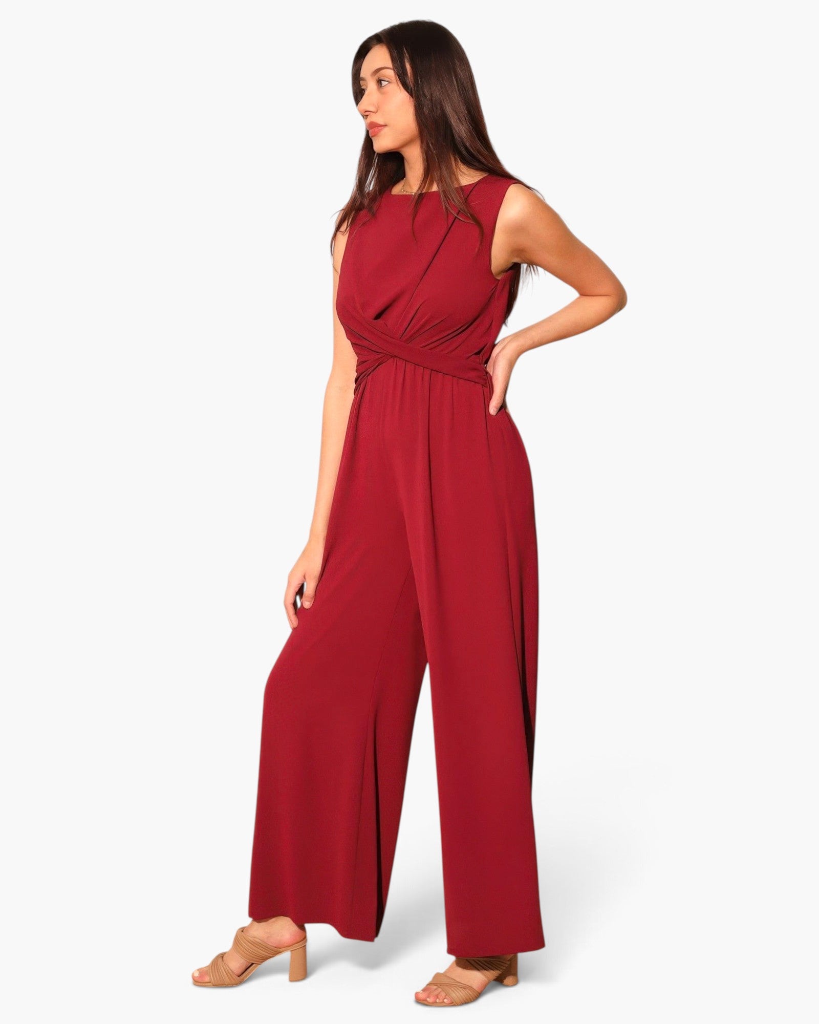 Beach Rose Co. model wearing a sleeveless deep red wide-leg jumpsuit with a flattering twist-front waist detail.