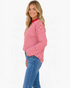 Beach Rose Co. red and white horizontal striped long sleeve top with a crewneck on a smiling model wearing jeans.