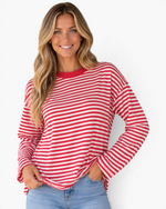 Beach Rose Co. model wearing a red and white horizontal striped long sleeve cotton top with a solid crew neckline.