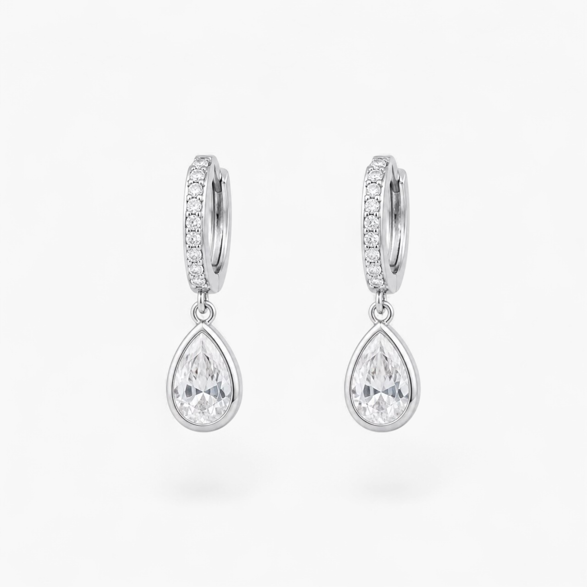Beach Rose Co. rhodium-plated huggie earrings with a sparkling cubic zirconia teardrop charm on a white background