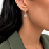 Beach Rose Co. rhodium teardrop huggie earrings with cubic zirconia stones worn on a model ear