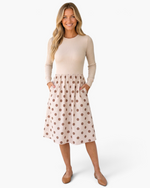 Beach Rose Co. beige ribbed long sleeve midi dress with a polka dot skirt and round neckline worn by a blonde model.