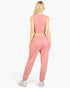 Beach Rose Co. rosewood pink French terry tank top and jogger set worn by a blonde woman, back view.