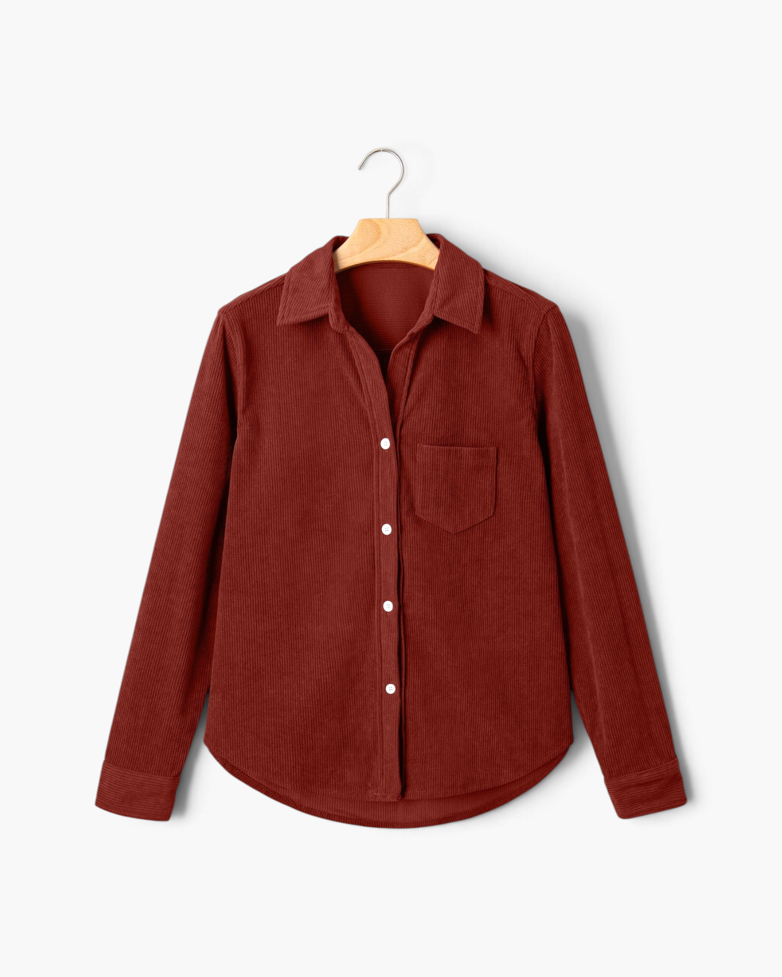 Beach Rose Co. rust corduroy button-front shirt with a pointed collar, chest pocket, and curved hem on a hanger.