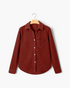 Beach Rose Co. rust corduroy button-front shirt with a pointed collar, chest pocket, and curved hem on a hanger.