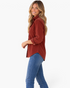 Beach Rose Co. rust corduroy button-front shirt with a chest pocket and curved hem worn by a smiling woman.