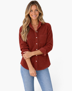 Beach Rose Co. rust corduroy button-front shirt with chest pocket worn by a smiling woman with long blonde hair.