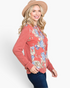 Beach Rose Co. rust floral print hoodie with relaxed fit and cuff detail worn by a smiling blonde woman in a hat