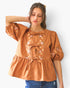 Beach Rose Co. rust-colored poplin blouse with floral embroidery, front ribbon ties, and puff sleeves on a model.