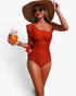 Beach Rose Co. rust orange one-piece swimsuit with asymmetrical ruffle shoulder and ruched side detail on a model