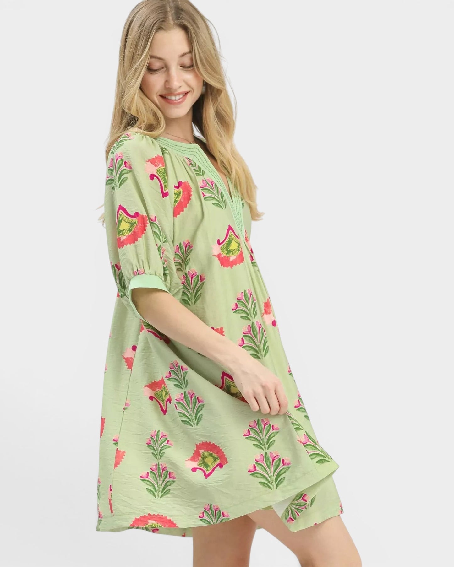 Beach Rose Co. sage green mini dress with pink, green, and coral floral print, split V-neck, and puff sleeves.
