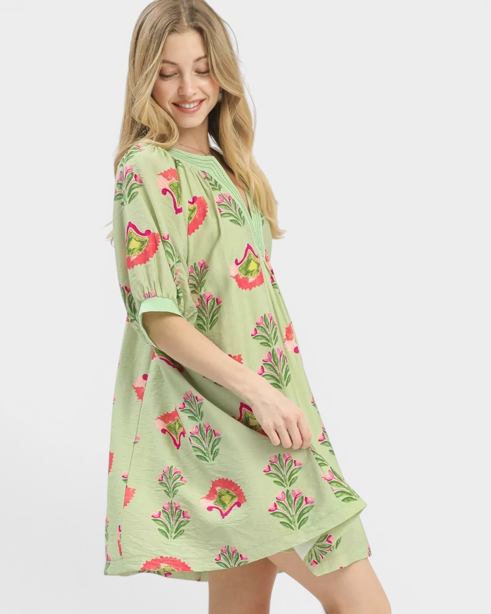 Beach Rose Co. sage green mini dress with pink, green, and coral floral print, split V-neck, and puff sleeves.