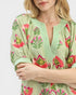 Beach Rose Co. sage floral mini dress with pink, green, and coral print, split V-neck, and puff sleeves.