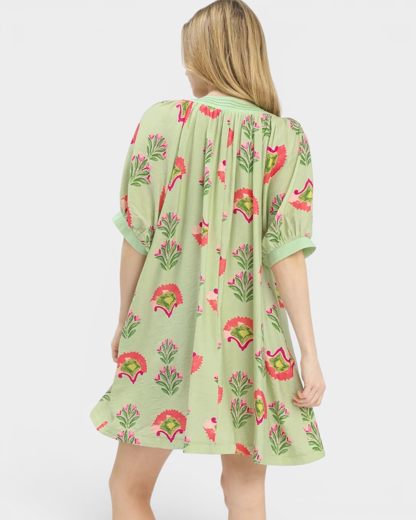 Beach Rose Co. sage mini dress with pink, green, and coral floral print. Features puff sleeves and a split V-neckline.