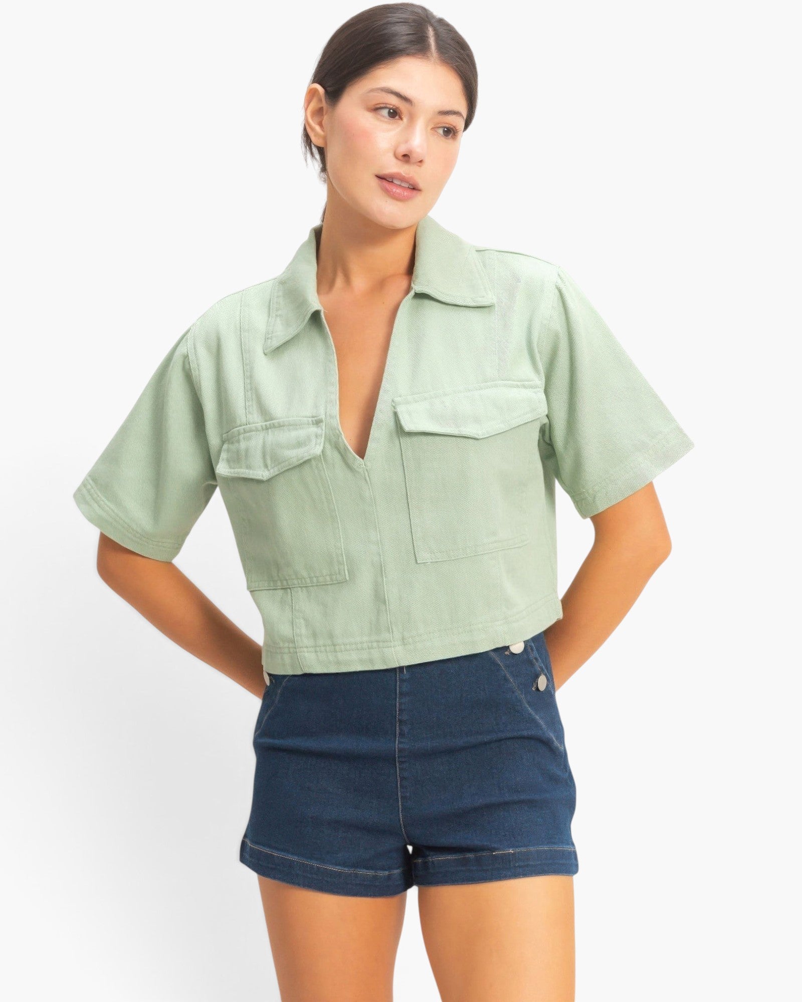 Beach Rose Co. sage green cotton collared V-neck top with short sleeves and two front flap pockets on a model