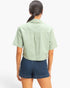 Beach Rose Co. sage green cotton collared cropped top with short sleeves, back view on a model