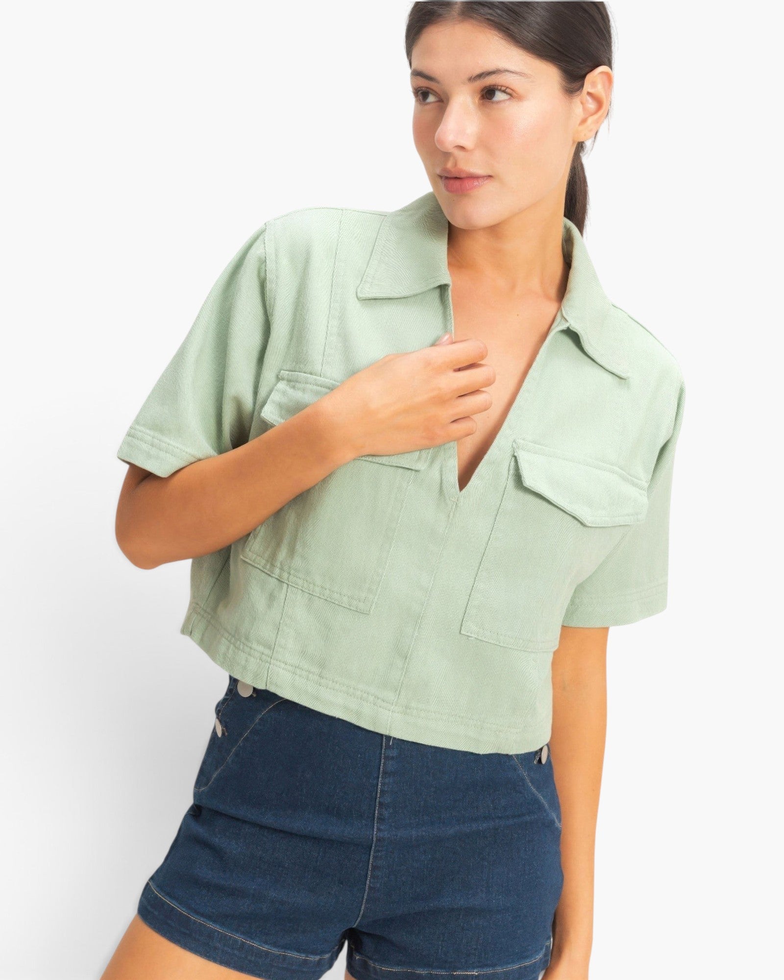 Beach Rose Co. sage green cotton cropped top with a structured collar, V-neckline, and two front flap pockets.