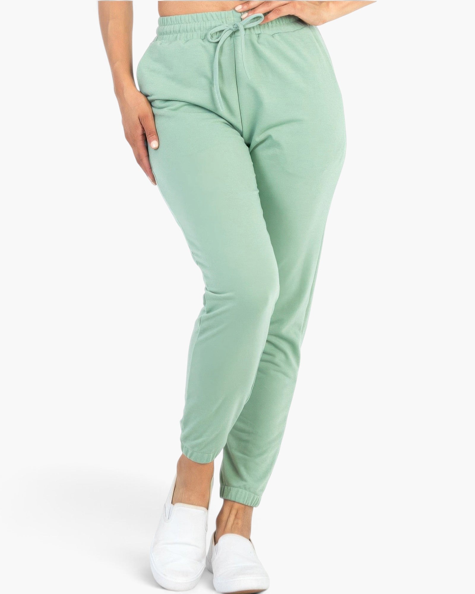 Beach Rose Co. sage green French Terry jogger pants with an elastic waistband and tapered cuffs on a model