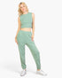 Beach Rose Co. sage green French terry tank top and joggers set worn by a blonde model with white sneakers