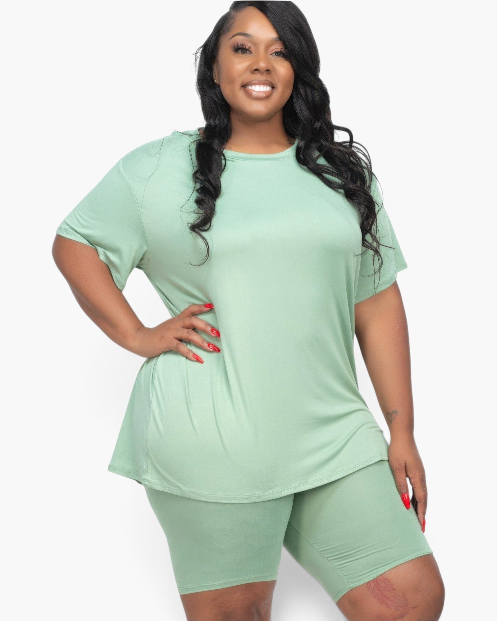 Beach Rose Co. plus size model wearing a sage green loose fit t-shirt and matching biker shorts set.