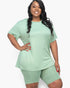 Beach Rose Co. plus size model wearing a sage green loose fit t-shirt and matching biker shorts set.