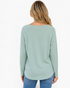 Back view of a Beach Rose Co. sage green textured long sleeve raglan top with a curved hem worn with blue jeans.