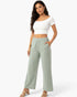 Model wearing Beach Rose Co. sage green relaxed fit wide-leg cotton pants with side pockets and a white crop top