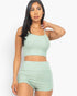 Beach Rose Co. model wearing a sage green ribbed cami crop top and matching high-waisted ruched shorts set.