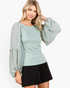 Beach Rose Co. sage smocked chiffon blouse with sheer balloon sleeves and ruffle trim worn by a blonde model