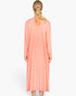 Back view of a model wearing a salmon-colored Beach Rose Co. ribbed long-sleeve cardigan over a matching midi dress.