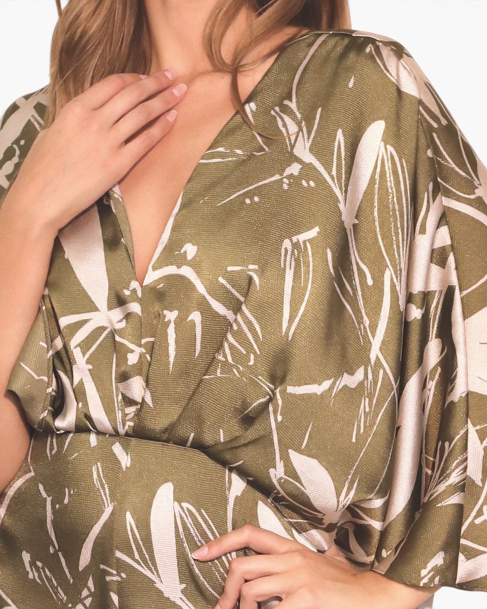 Beach Rose Co. Dreaming Lily satin cape jumpsuit in olive green with a white floral print and elegant draped sleeves.