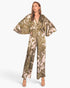 Beach Rose Co. Dreaming Lily satin cape jumpsuit in olive green with a floral print and dramatic flowing sleeves.