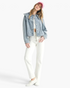 Beach Rose Co. light wash denim jacket with an oversized scalloped collar worn by a model in a pink baseball cap.
