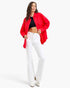 Model wearing a Beach Rose Co. scarlet oversized denim shirt jacket with buttoned pockets and a curved hem.