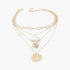 Beach Rose Co. gold chain necklace featuring seashell and starfish charms with pearl accents for a coastal look
