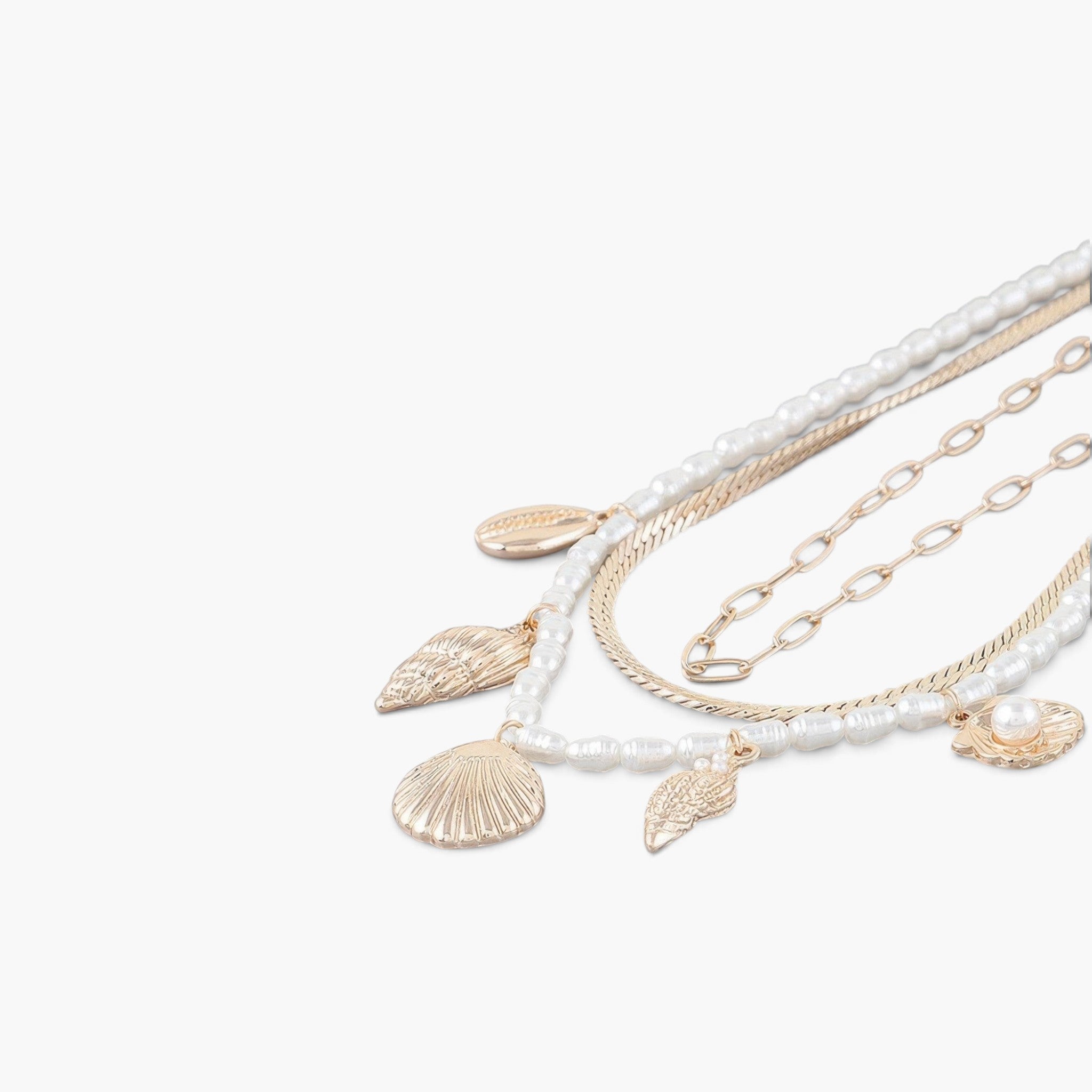 Beach Rose Co. multi-strand necklace featuring gold chains, white pearls, and delicate gold seashell charms.