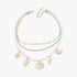 Beach Rose Co. multi-strand necklace featuring gold chains, white pearls, and dangling gold seashell charms.