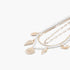 Beach Rose Co. multi-strand necklace featuring gold chains, white pearls, and delicate gold seashell charms.