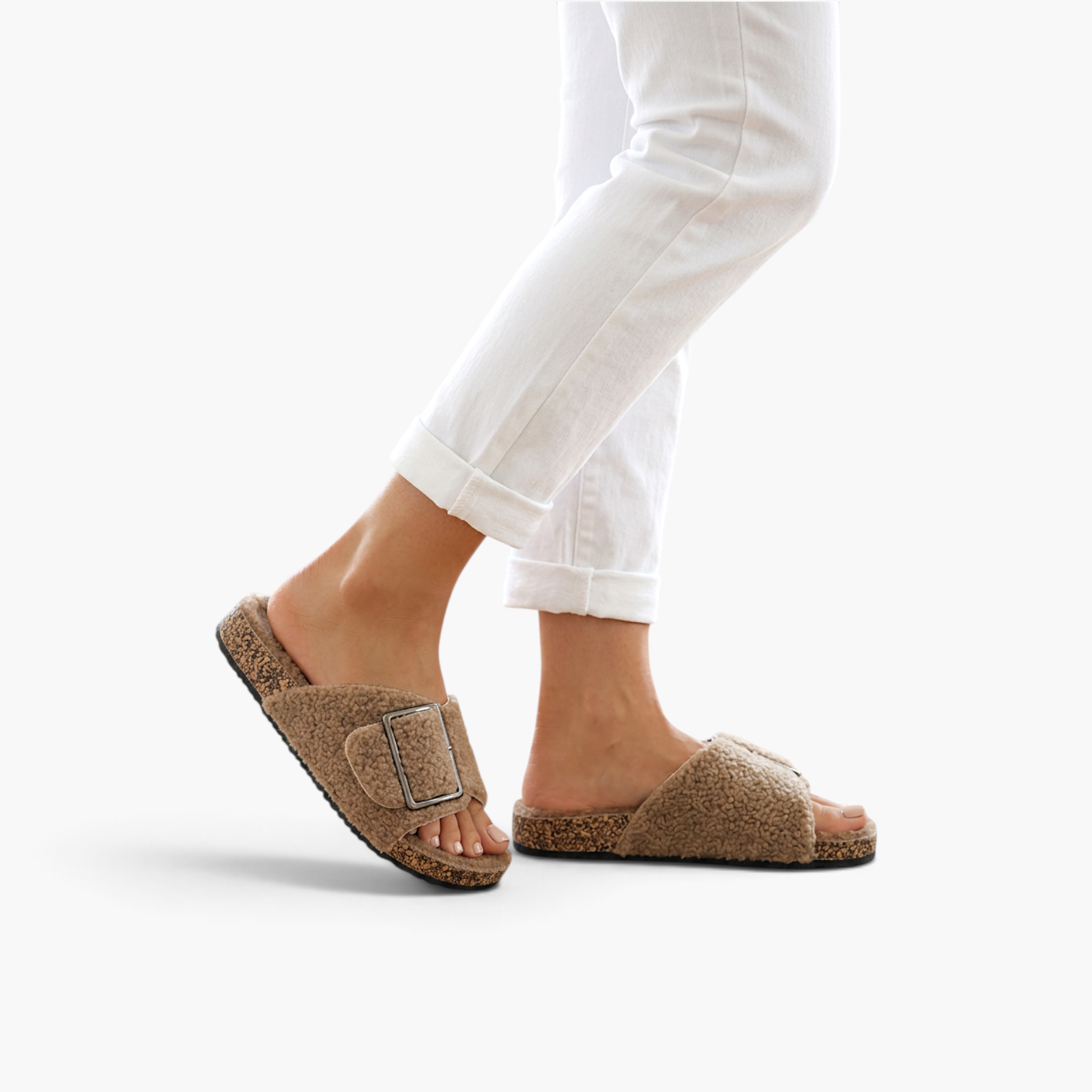 Beach Rose Co. Rochelle beige vegan suede sherpa slippers with a metal buckle and cork-style sole on a model