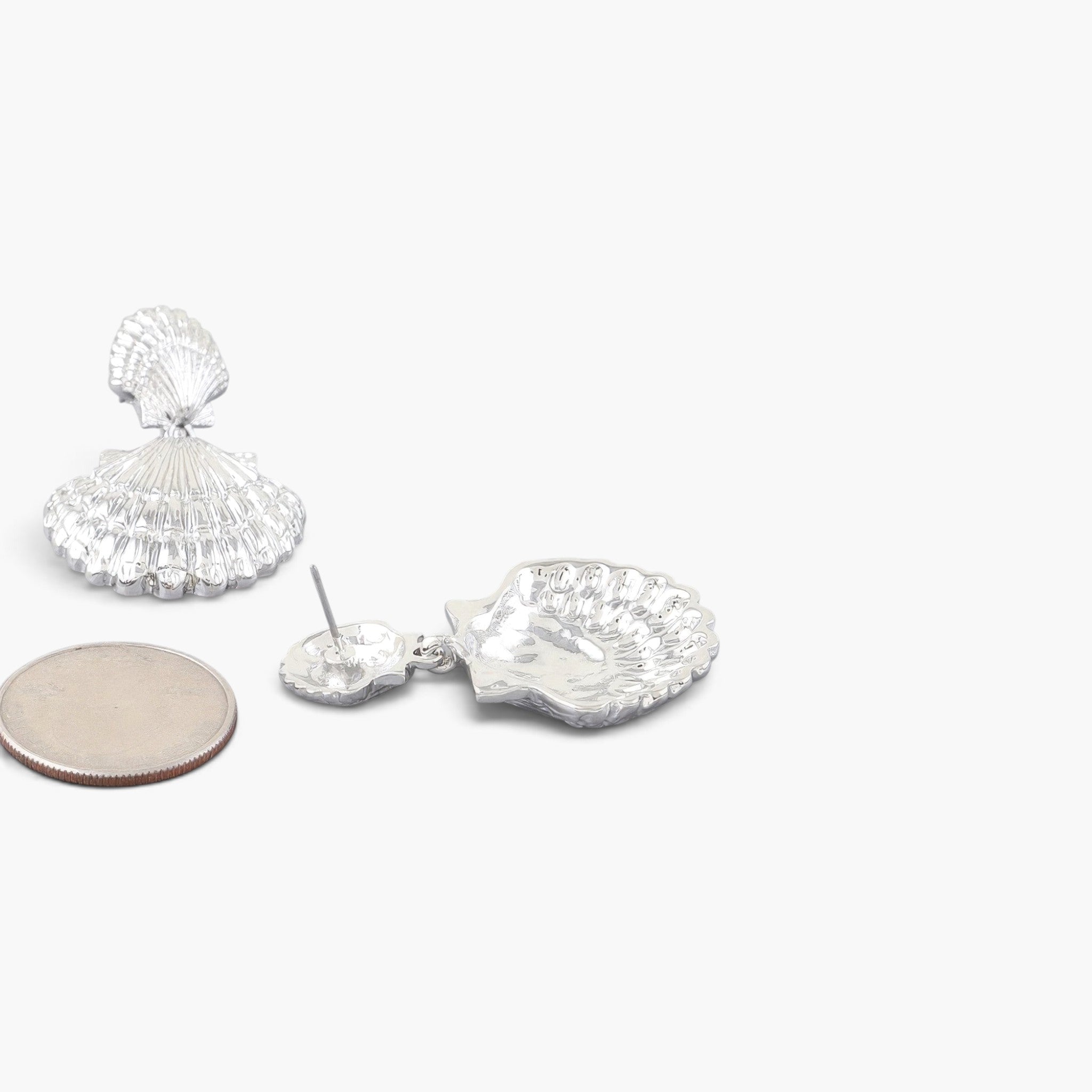 Beach Rose Co. silver double clamshell drop earrings with intricate textured detail next to a US quarter coin.