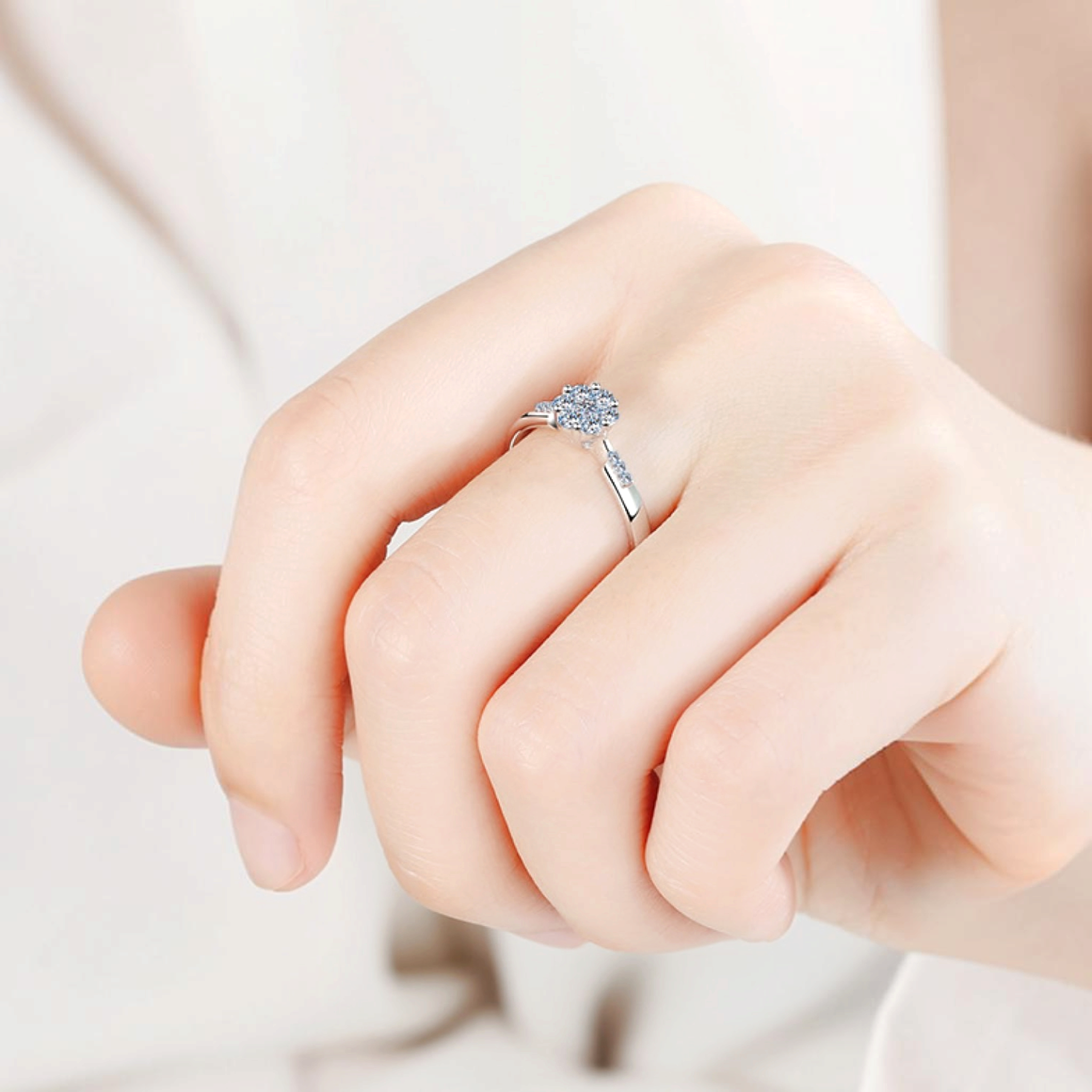 Beach Rose Co. silver floral cluster ring with moissanite and zircon stones worn on a finger