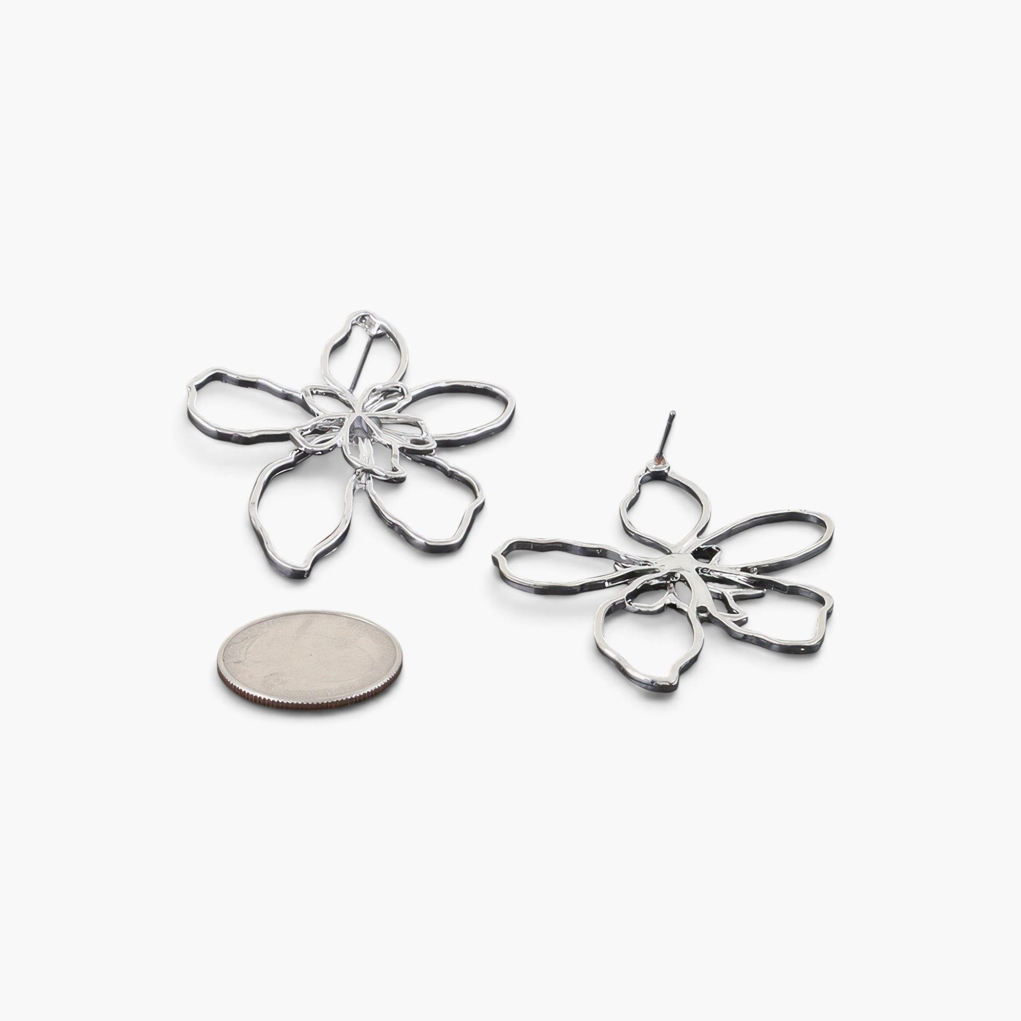 Beach Rose Co. silver-tone abstract flower earrings with delicate openwork design shown next to a coin for scale.