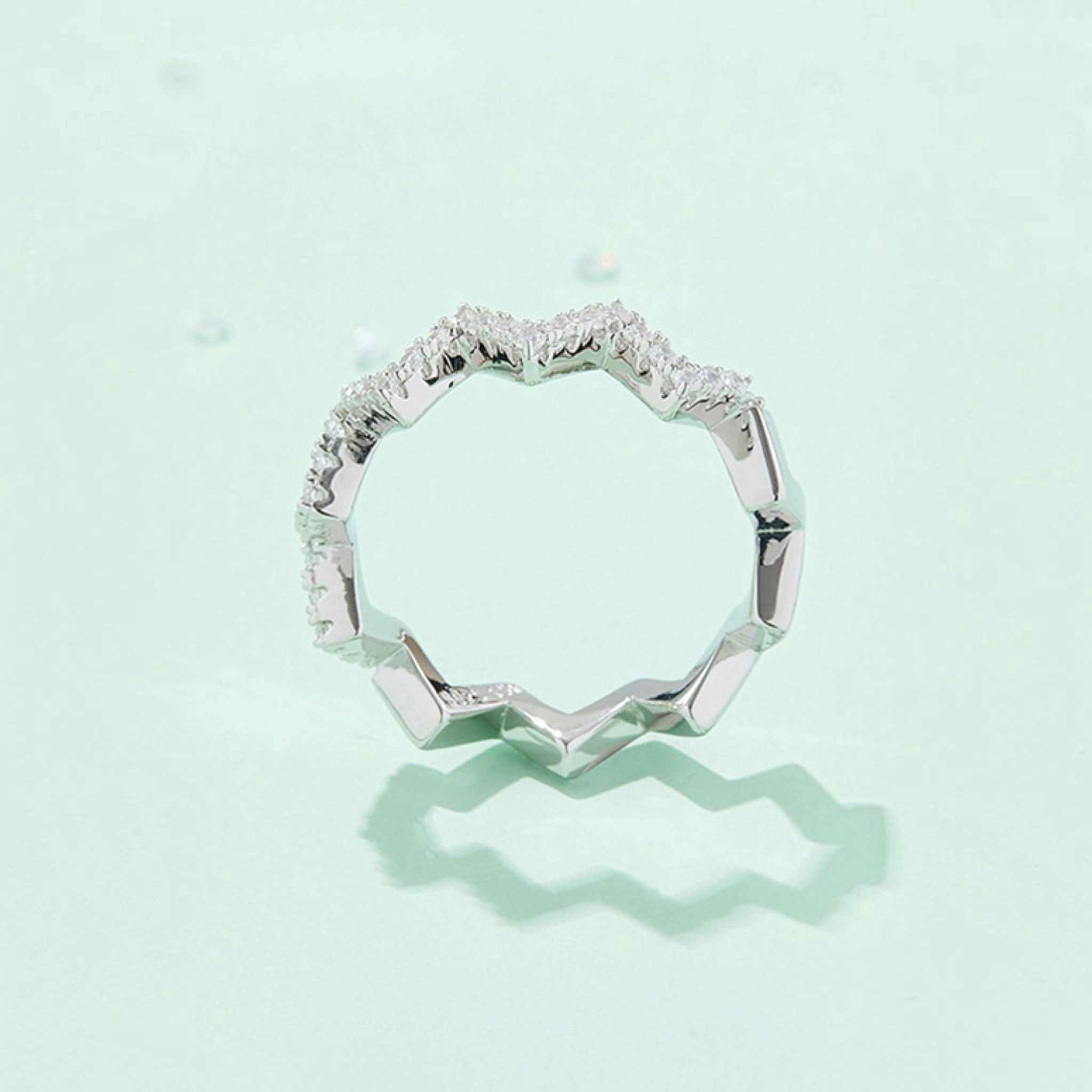 Beach Rose Co. platinum-plated sterling silver zigzag band ring featuring 0.38 carat round moissanite stones.
