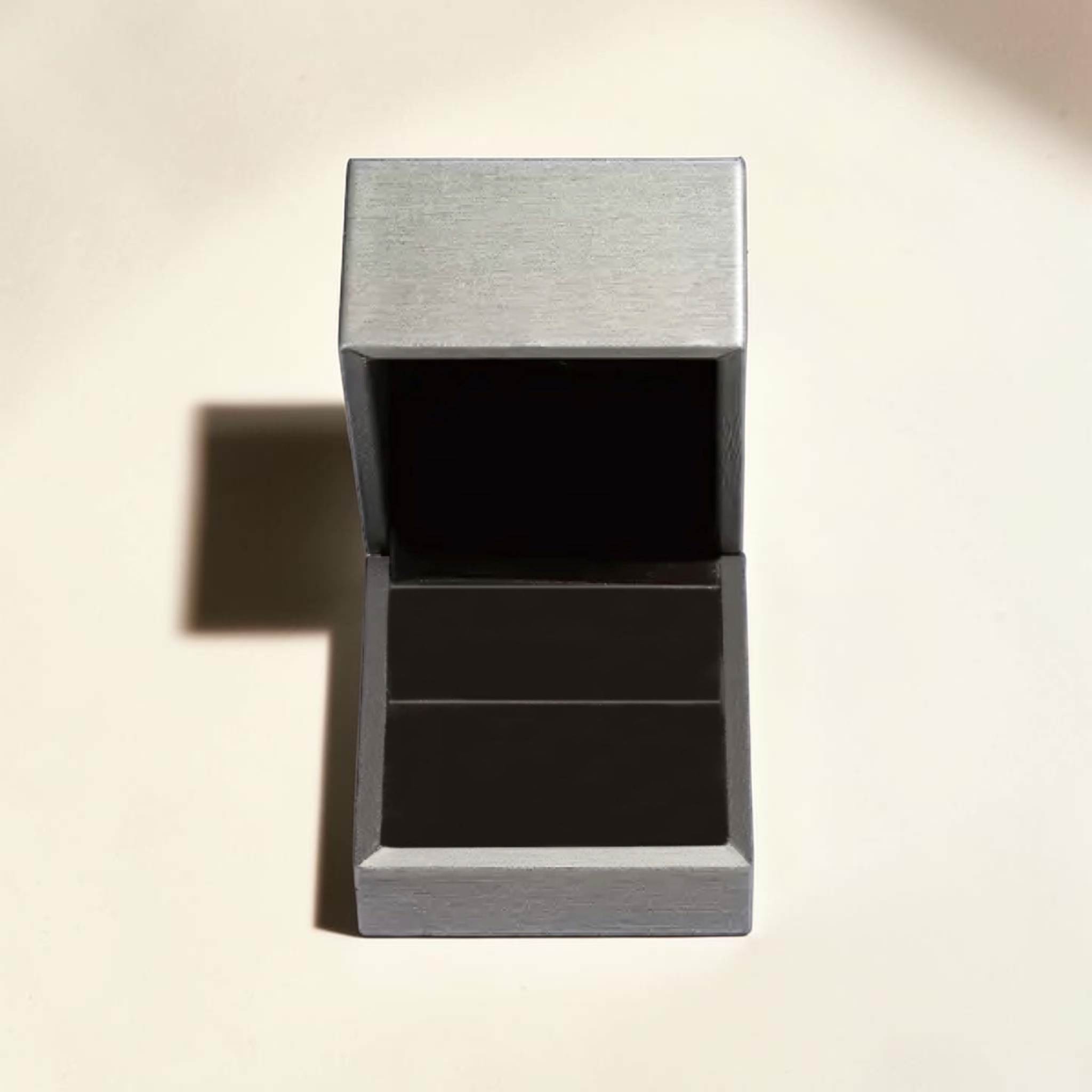 Beach Rose Co. silver ring gift box with a textured finish and dark interior, presented on a neutral background.