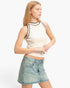 Beach Rose Co. sleeveless ribbed knit top in cream with black contrast trim, worn by a model with a denim skirt.