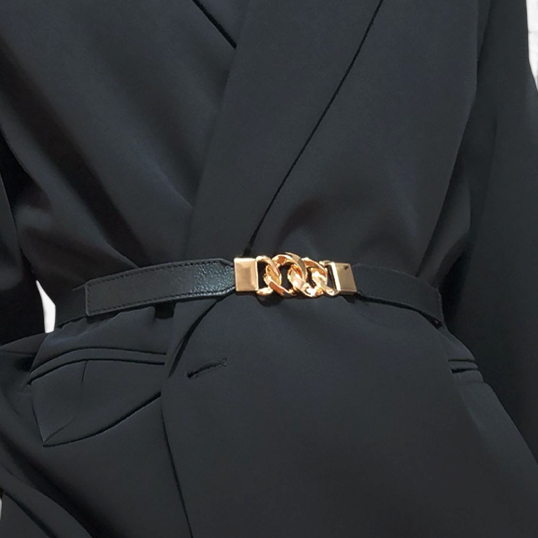 Beach Rose Co. slim black stretch waist belt featuring a gold-toned chunky chain-link buckle worn over a black blazer.